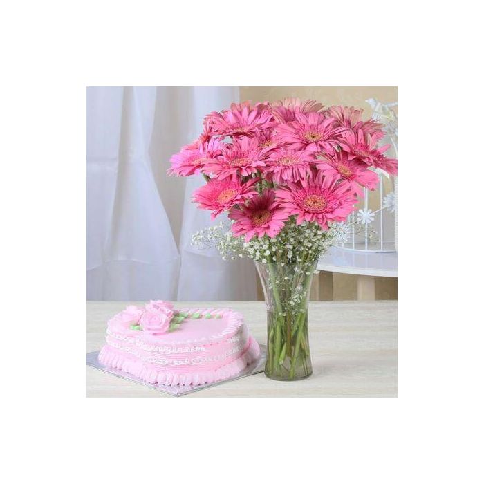 A 1 Kg strawberry cake accompanied by a bunch of fresh pink gerberas.