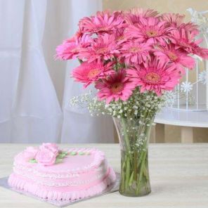 A 1 Kg strawberry cake accompanied by a bunch of fresh pink gerberas.